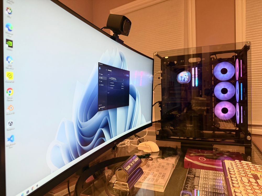 On the left is a computer monitor with an installation of Unity on the screen. On the right is a desktop computer with purple and pink fans. The PC case has a tempered glass cover.