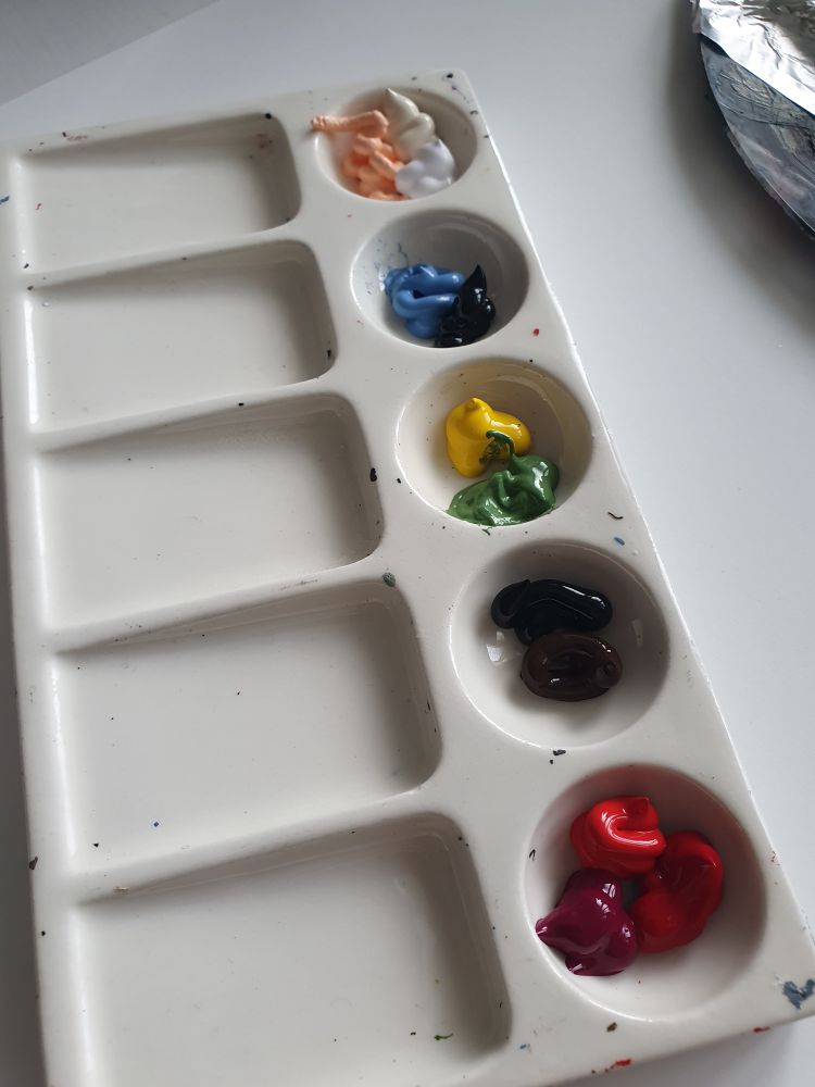 Porseleinen palet met klodders verf in verschillende kleuren 