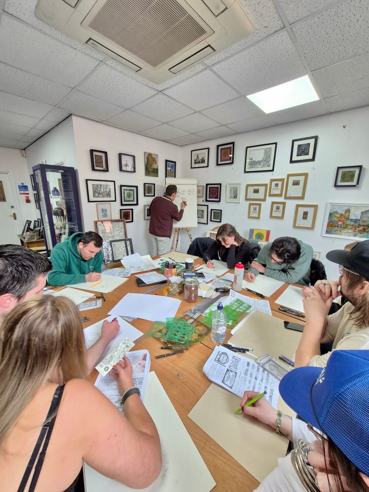 Photo of students drawing maps at a workshop by Manuscript Maps with artist Kevin Sheehan demonstrating drawing.