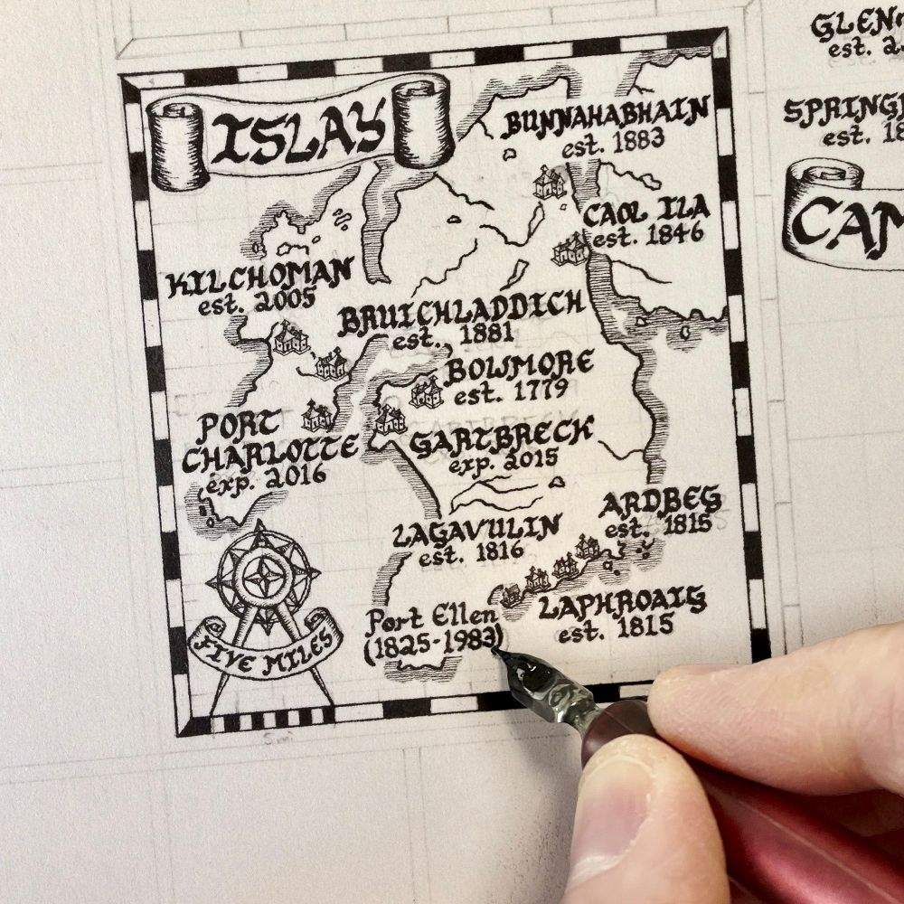 Photo of artist Kevin Sheehan handwriting calligraphy on the Islay inset map on his Scotland Whisky Map.