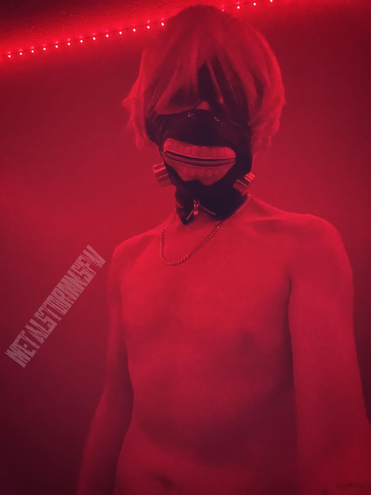 Metal in cosplay, standing in red lighting. 