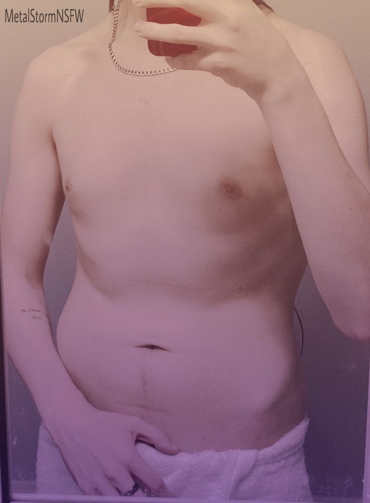 A mirror selfie of metal with a white towel around his waist. His hand is on the towel almost pulling it down. 