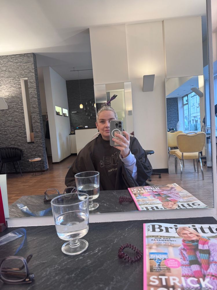 Selfie beim Friseur mit Farbe im Haar. 