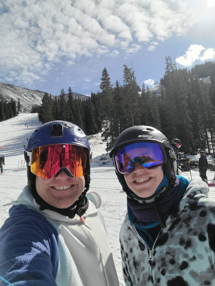 A donkey and leopard seal kigu on a ski hill under a wavey clouded sky.