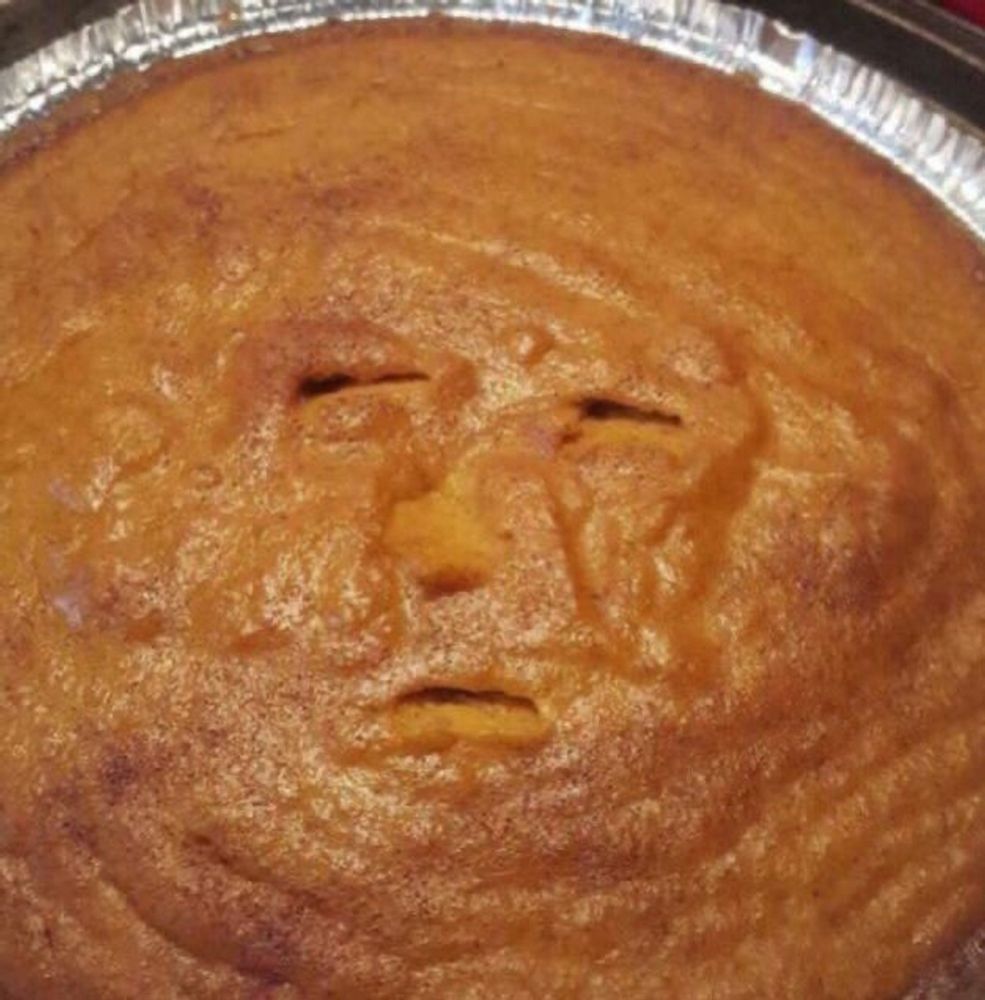 A pumpkin pie with a suspicious face carved