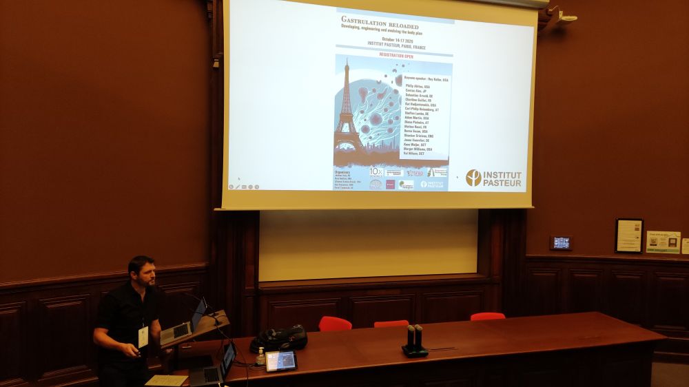 Jerome standing in front of a projected slide. The slide shows the poster of the meeting, with the title GASTRULATION RELOADED.