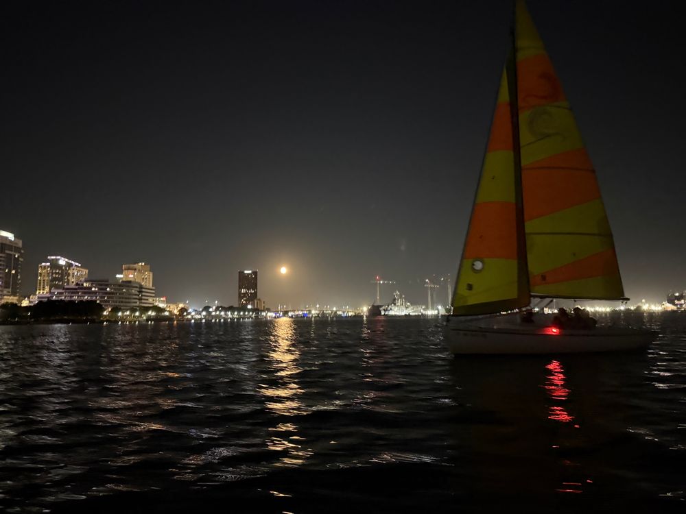 Moonrise over downtown Norfolk, with a sailboat. 