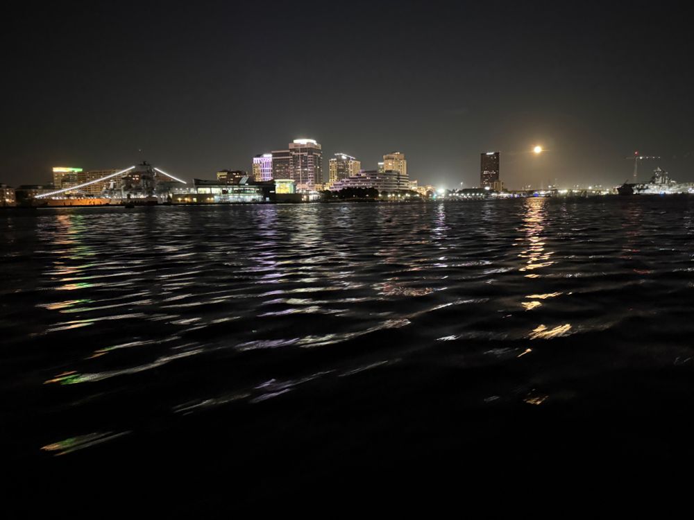 Moonrise over downtown Norfolk.  The Battleship Wisconsin is at the left, with two long strings of lights. 