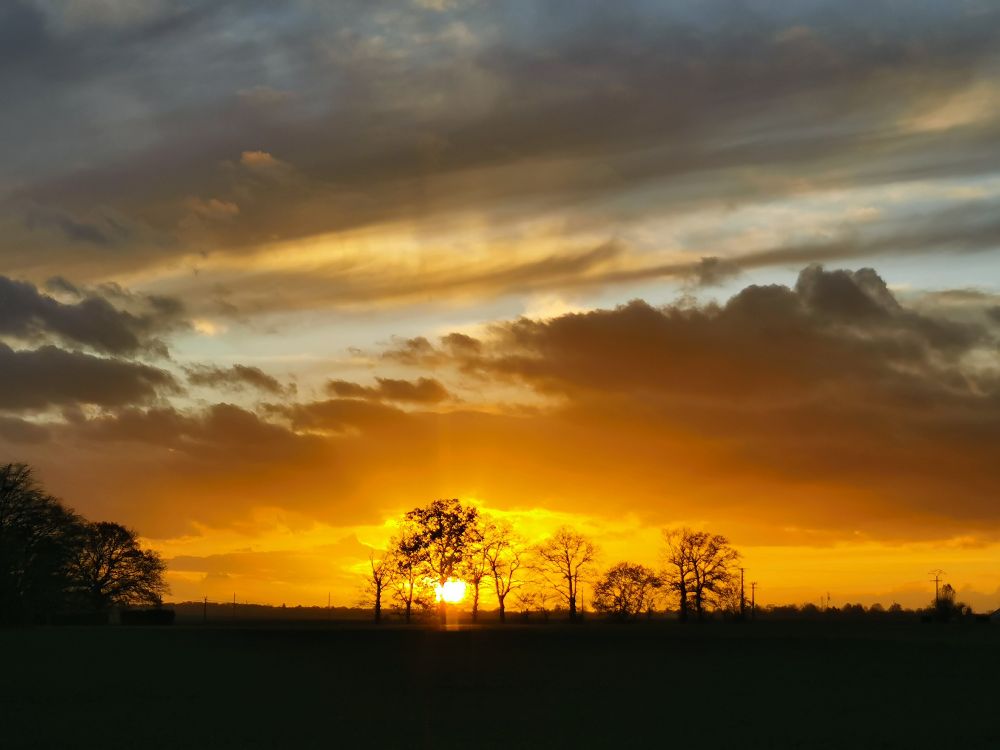 Coucher de Soleil dans l'Eure. Les nuages prennent une teinte orangée. 