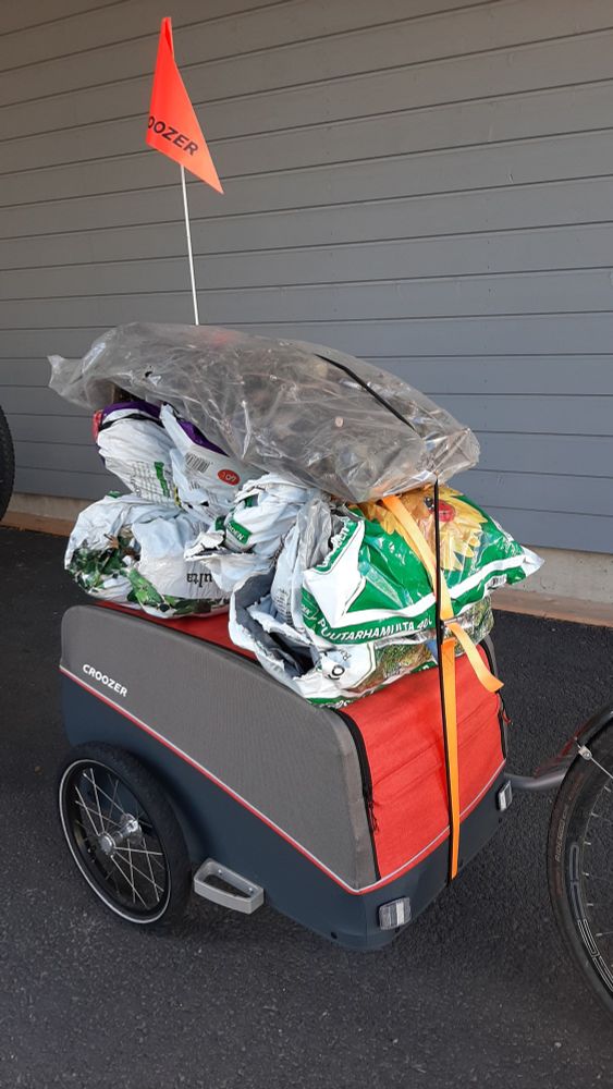 Pyöräkärry, jonka päällä (ja sisällä) on oksia käytetyissä multasäkeissä.