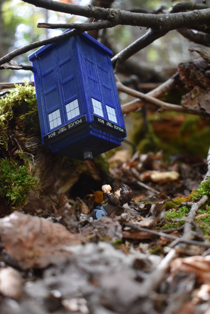 The Fourth Doctor looking up at the TARDIS which is suspended upside down over him.