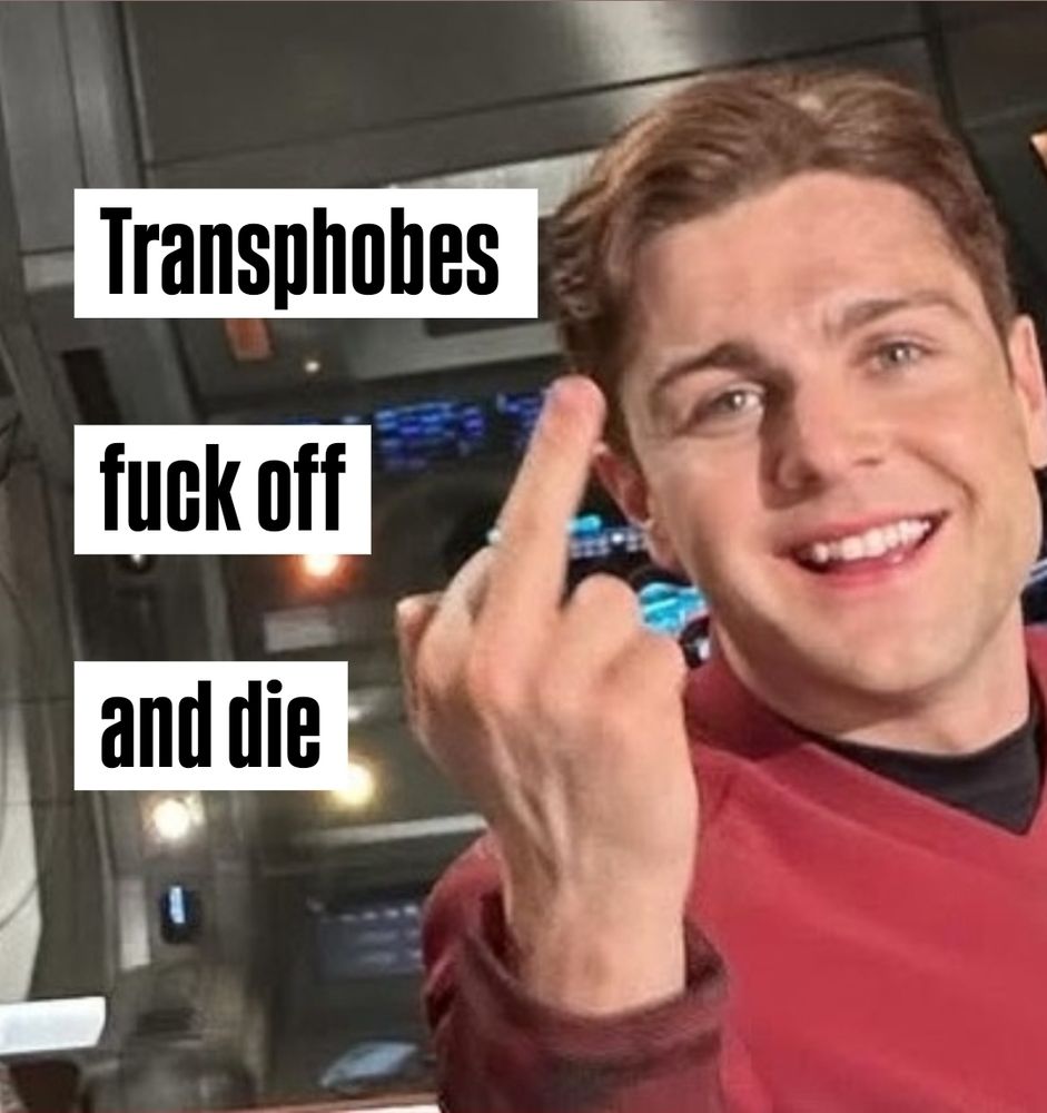 Behind the scenes photo of Martin Quinn in costume as Scotty on Star Trek Strange New Worlds, smiling while flipping off the camera. The picture is cropped so he's on the right side of the picture and his erect middle finger is centered. The caption in blocky text on the left side of the picture says 