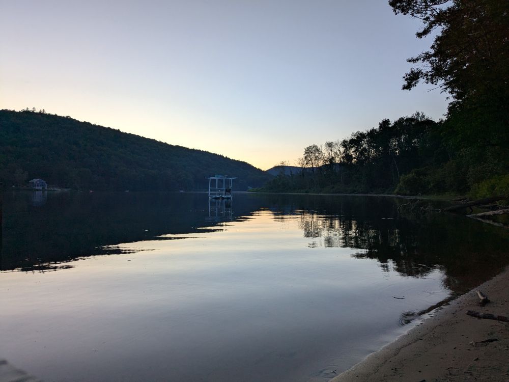 Twilight over Echo Lake in Vermont. A gentle mountain and treeline reflected in the lake.