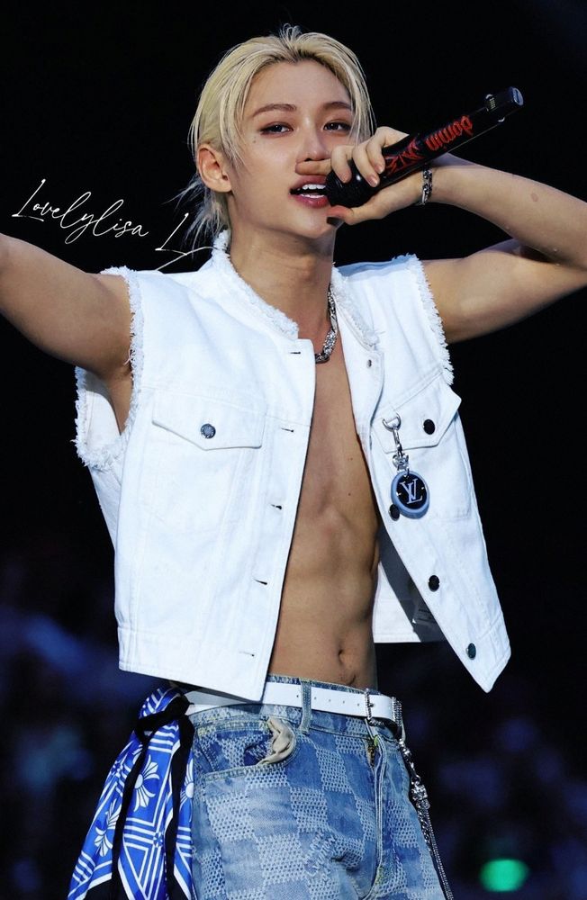 felix singing, in a white denim vest hat's open, exposing his abs and showing a bit of happy hair lol below his navel