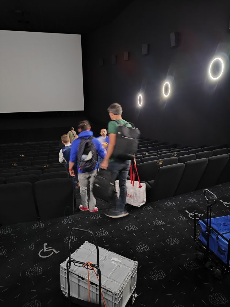 Des personnes dans une salle de cinéma pour la préparation d'une soirée Superman.