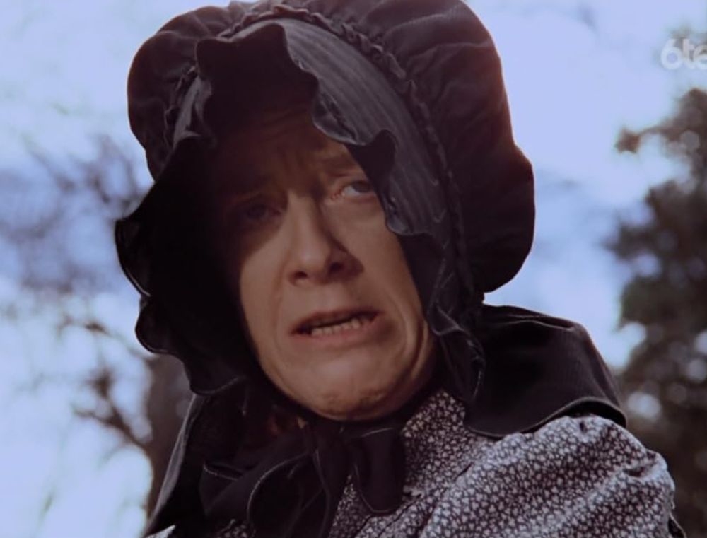 A photo of the character Ms. Peel from a Little House on The Prairie episode, who couldn't read but ruled a community holding the bible up as her symbol of authority and leadership.  