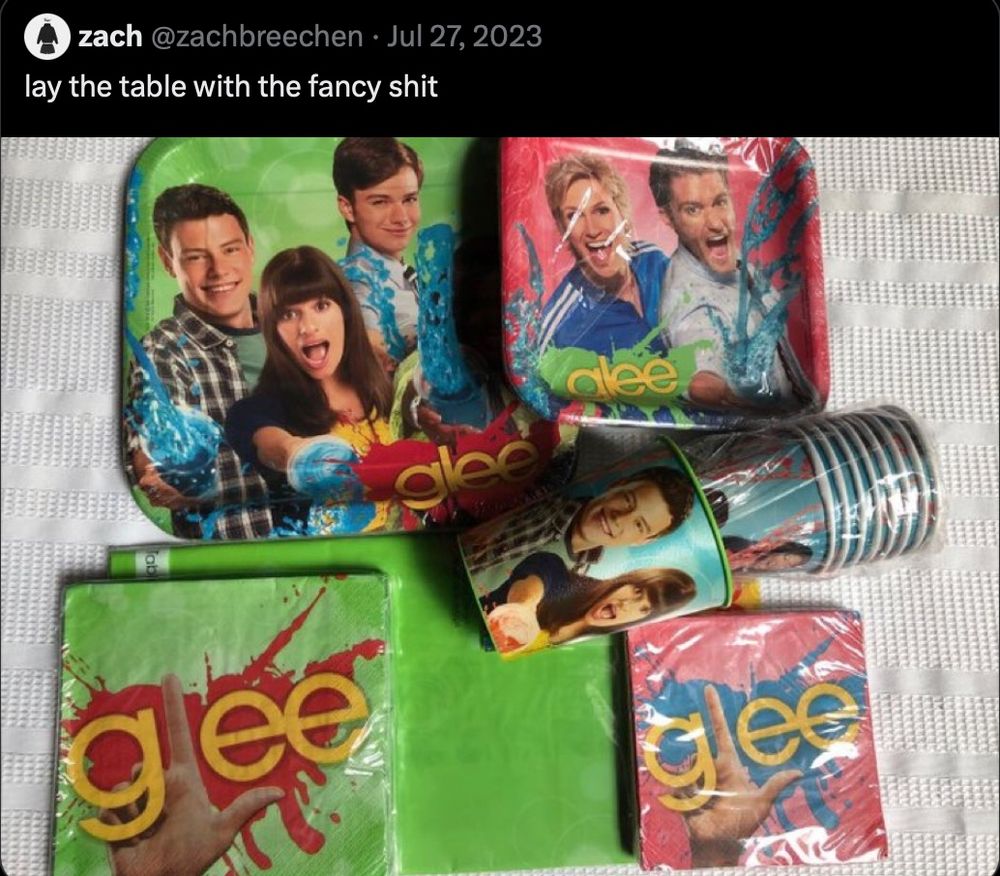 A tweet from zach (@zachbreechen) on July 27th, 2023:
“lay the table with the fancy shit”
An image of a set of green and red Glee branded paper plates, napkins and cups still in packaging is attached.