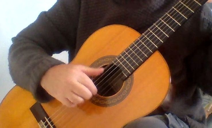 Main droite de guitariste jouant un morceau
