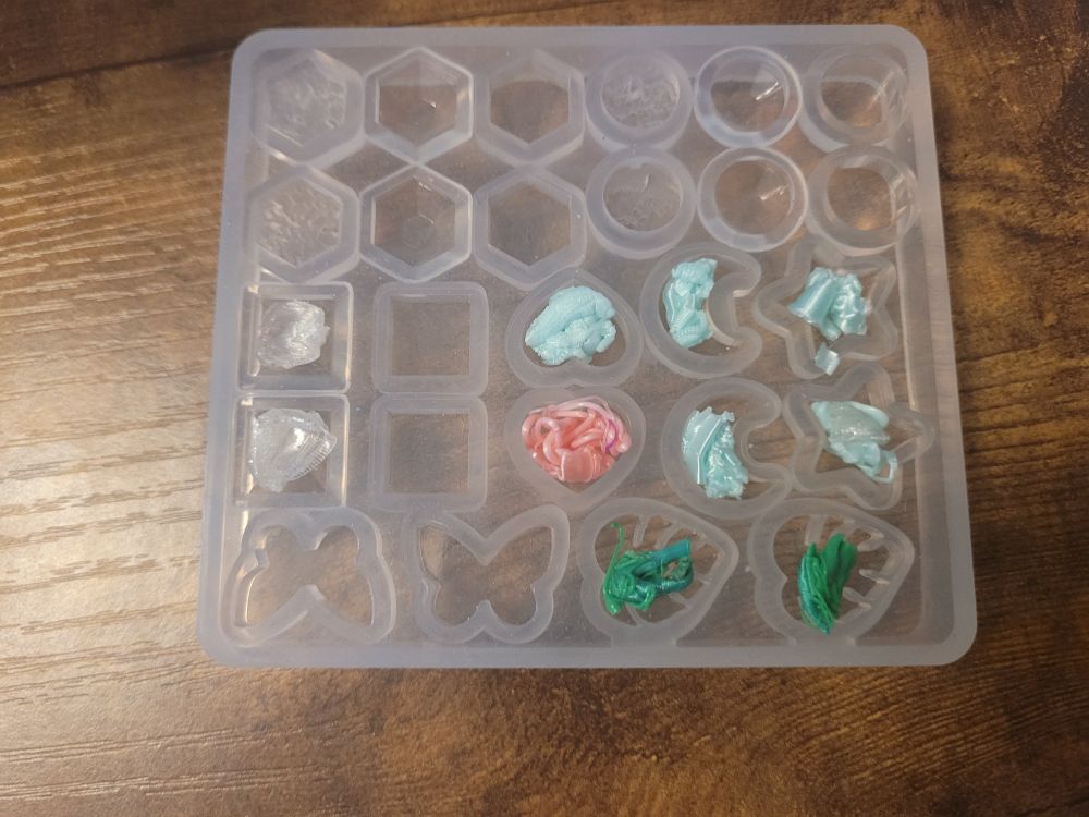 Little balls of PLA that were heated by my heat gun to fit into the charm molds that will get baked.