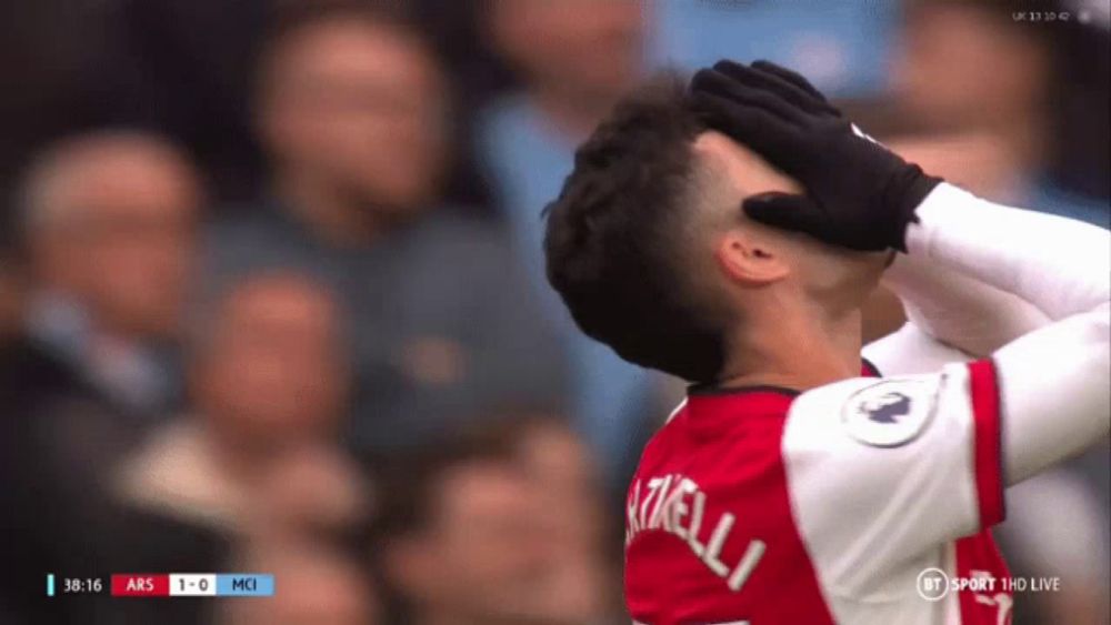 a soccer player covering his face with his hands while watching a game on bt sport