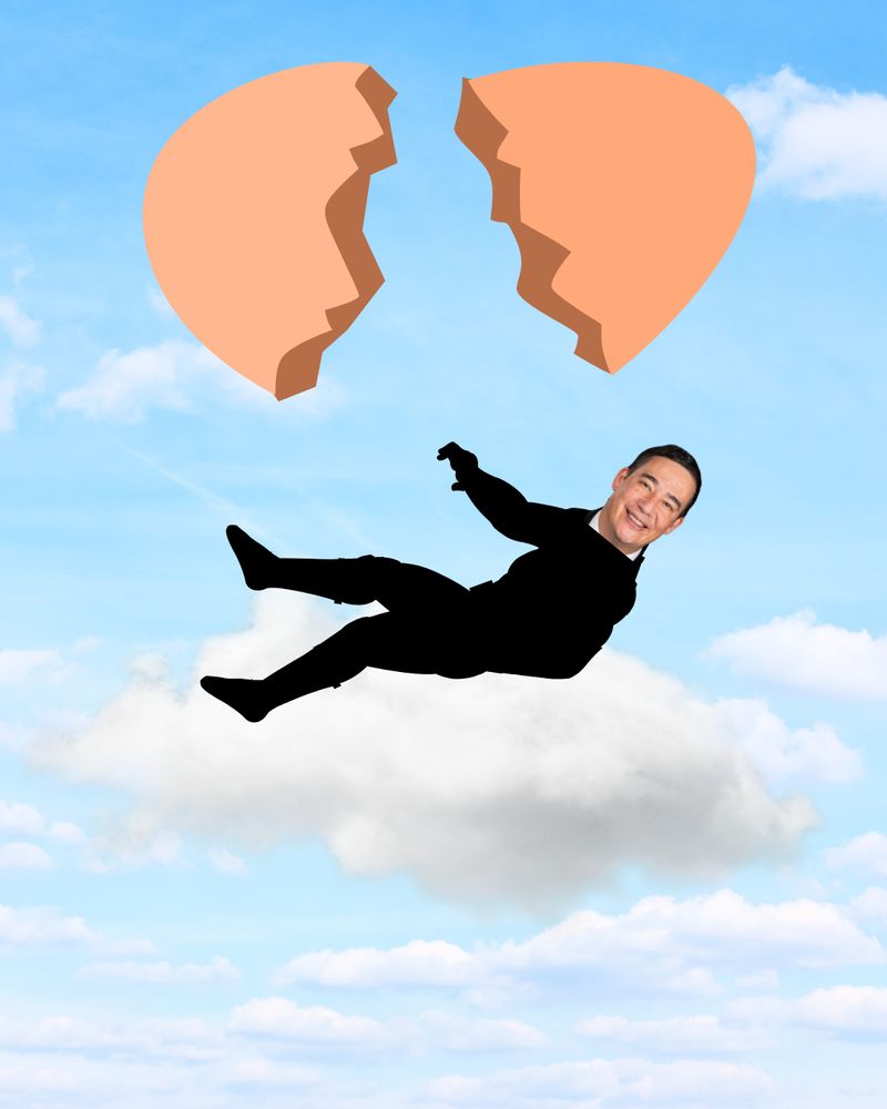 The bad Photoshop of Secretary Hobbs in a suit joyfully falling onto a cloud, with a broken egg graphic above, is set against a blue sky with light clouds.

