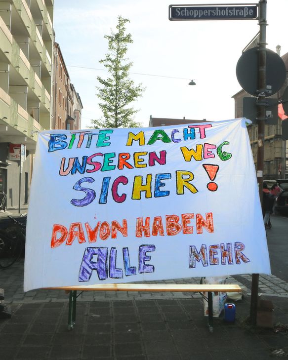 Foto von einem bunten selbstgemalten Banner: Bitte macht unseren Weg sicher! Davon haben alle mehr.