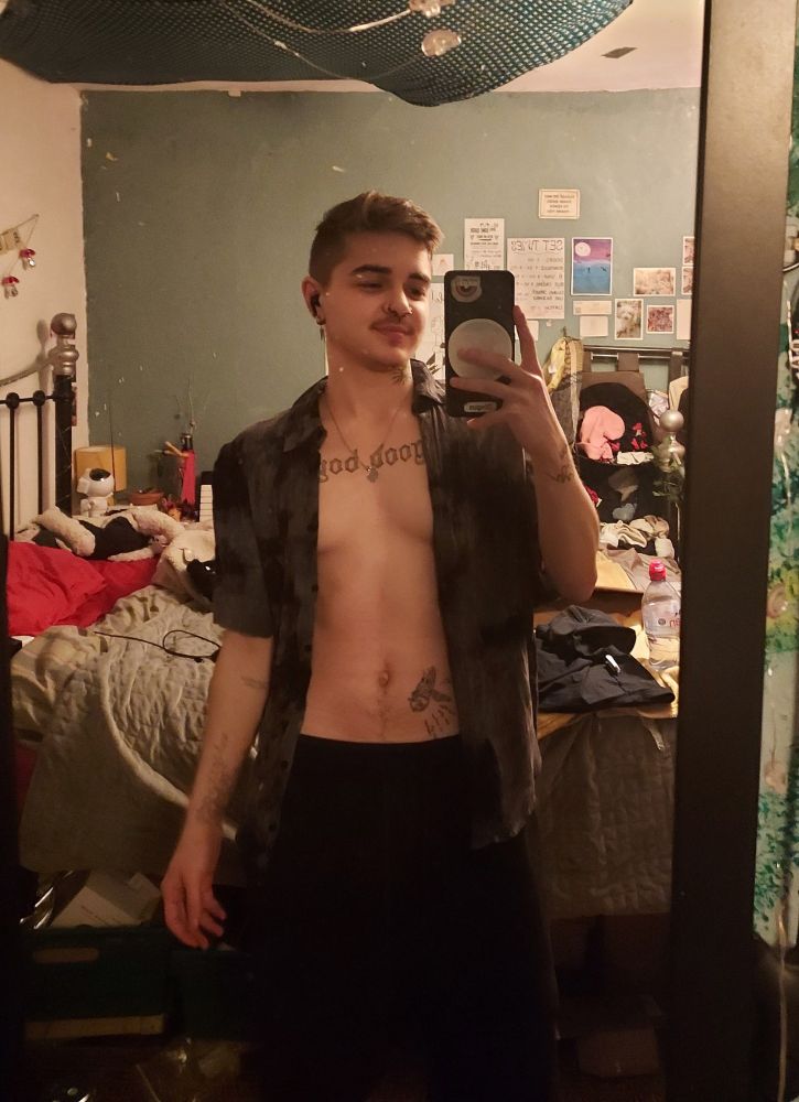 Me (white boy with tattoos), mirror selfie , I'm wearing an unbuttoned shirt and black shorts. 