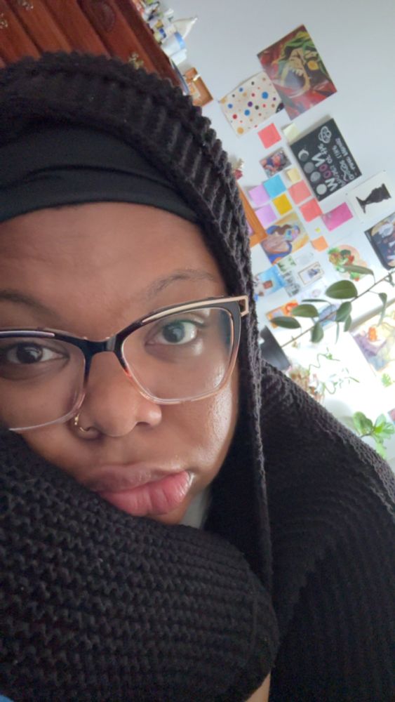 Picture of me lying down with a black hood on and glasses