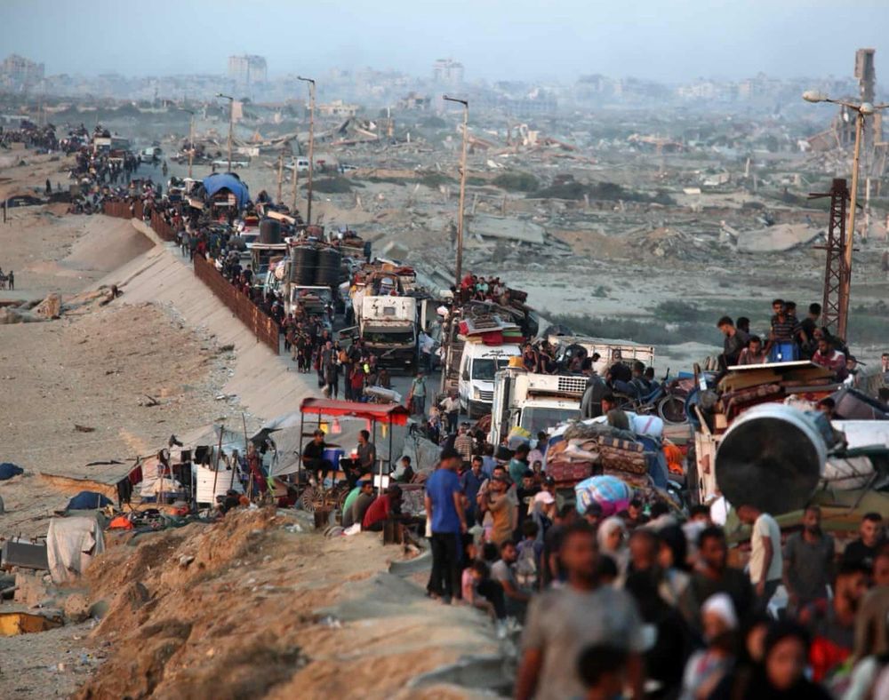 A long column of refugees, fleeing a destroyed landscape.