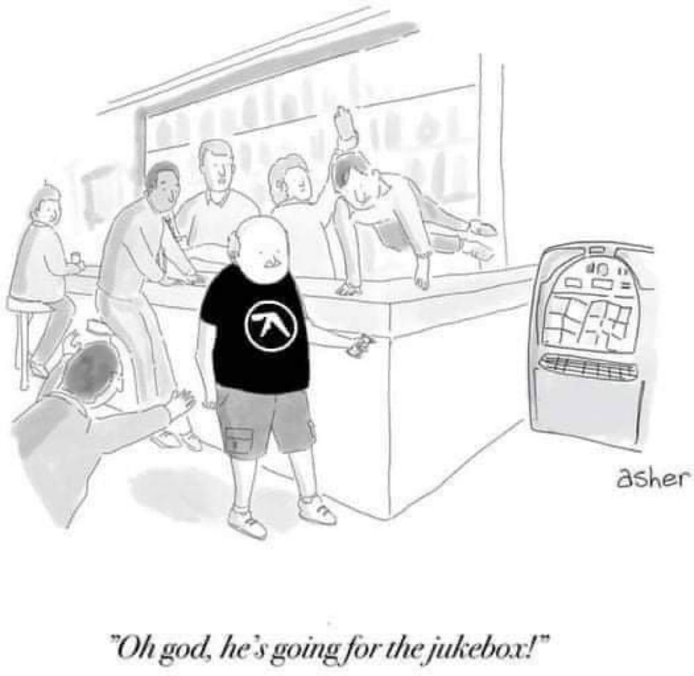 Das Bild zeigt einen Mann, der in einem T-Shirt des Eletro/Technomusikers Aphex Twin auf eine Jukebox zugeht.