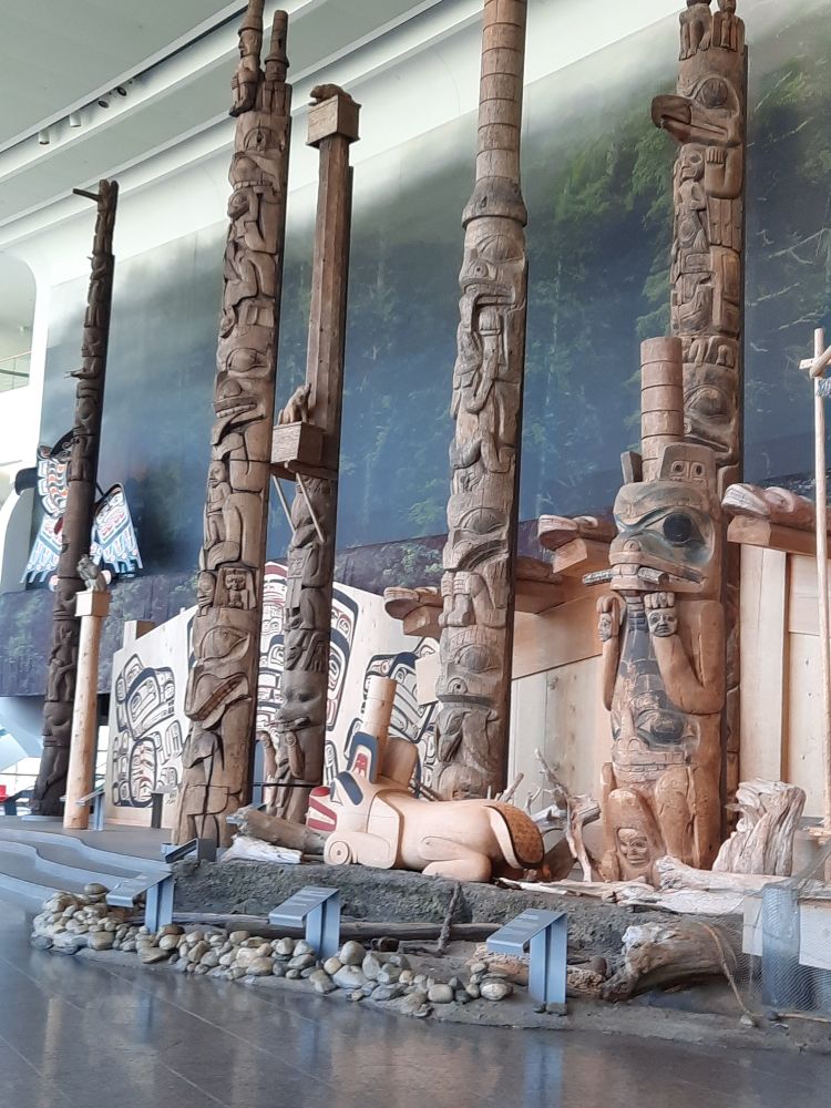 Five different totem poles, expertly carved by indigenous artists, line the Grand Hall of Canada's Museum of Civilization (now History). Behind them is a replica of a Pacific Coast village.