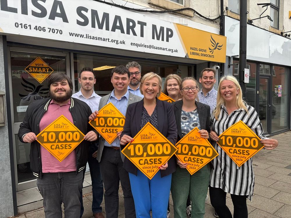 Lisa Smart MP and the team outside the Romiley Constituency Office with “10,000 cases” Lib Dem Diamonds