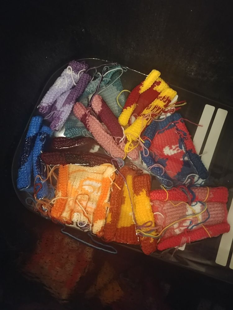 A photo of a bunch of crochet squares with Sonic characters on them, inside a black bathtub