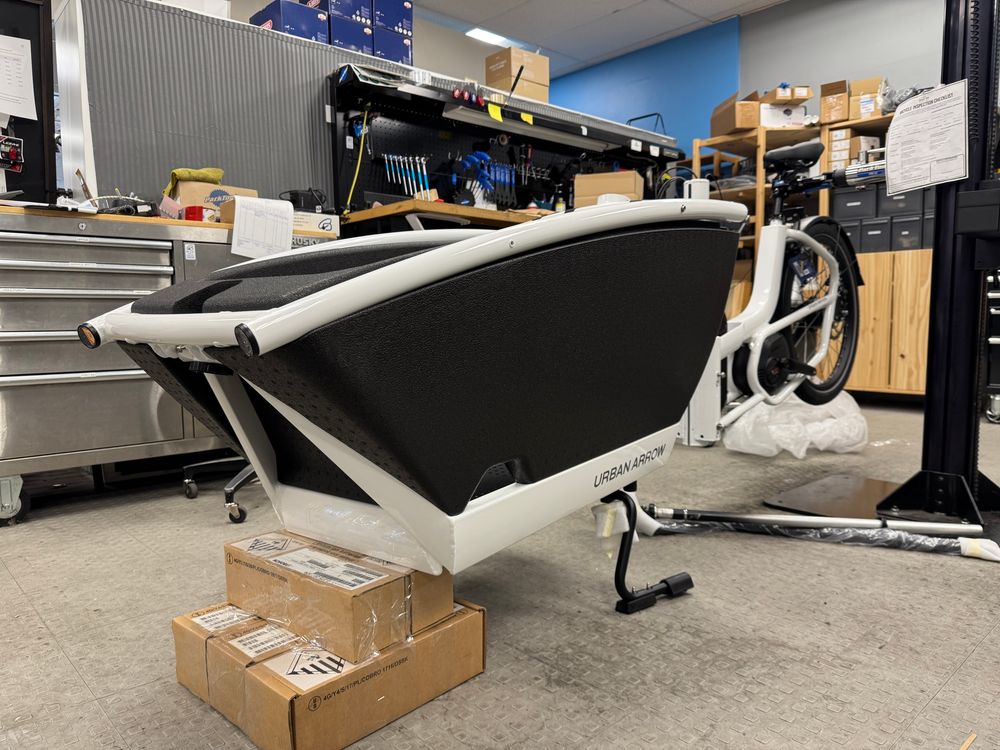 A partially assembled Urban Arrow bakfiets in a bikeshop