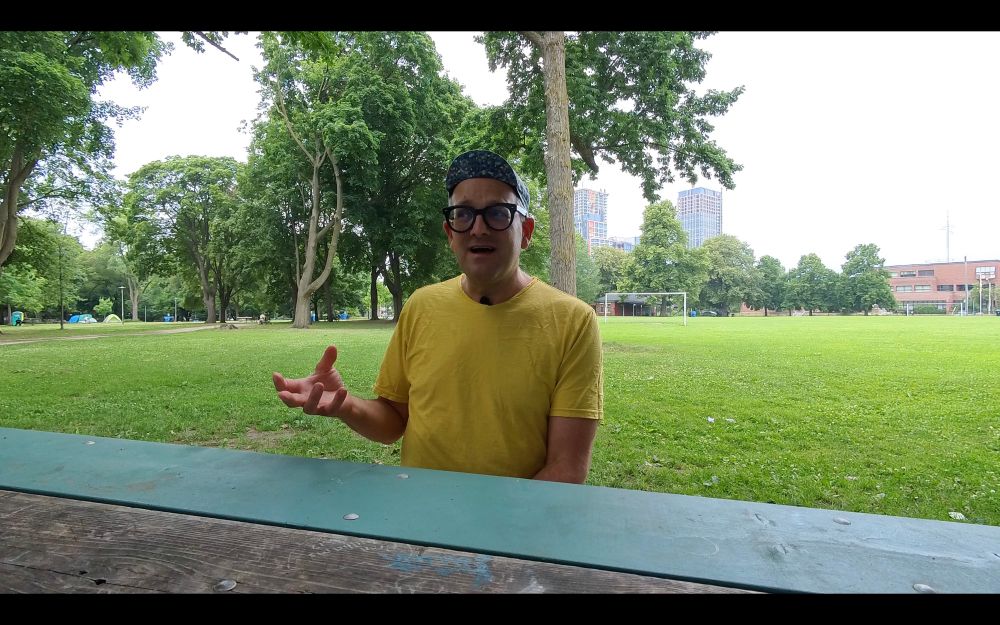 Shawn Micallef at a picnic table in Toronto’s Dufferin Grove Park. 