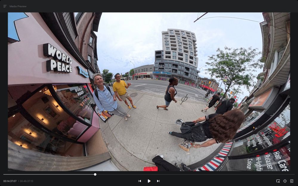 A fish eye angle shot of Mark Wihak and Shawn Micallef walking along Bloor Street in Toronto. 