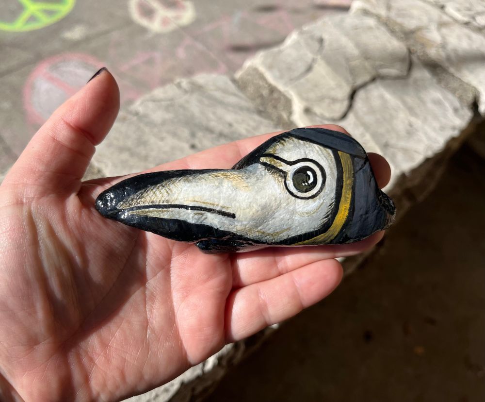 A rock painted to look like a plague doctor mask, and amazing shaped just like it too.
