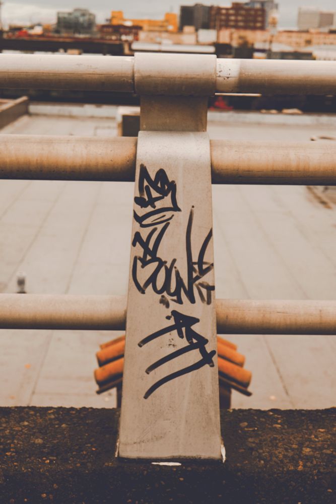 Graffiti on a bridge guardrail support. 