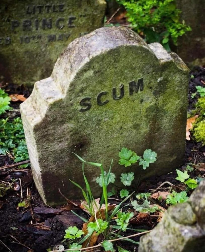 A small weatherbeaten gravestone bearing just the word SCUM