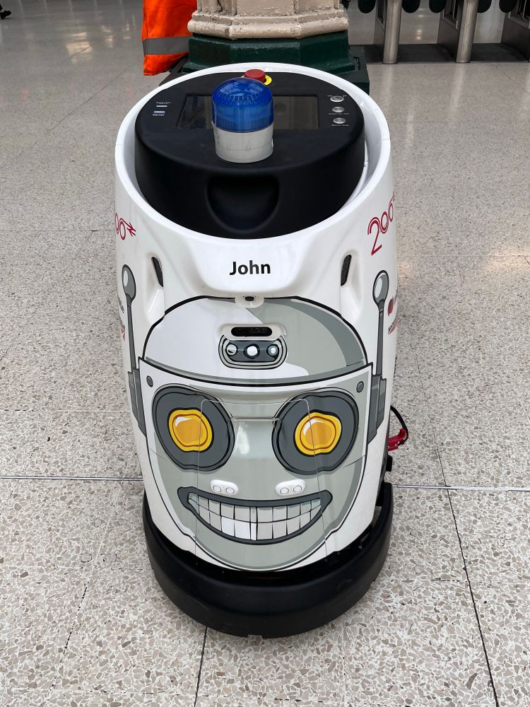The autonomous cleaning robot that menaces passengers at London’s Charing Cross station. It now has a sticker saying that it’s called ‘John’ and an illustration of a crazed robot face 