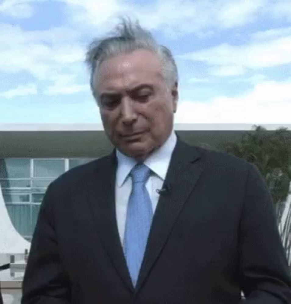 a man wearing a suit and tie is standing in front of a building .