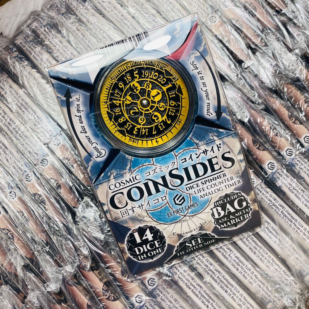 A box full of CoinSides dice spinners in the packaging 