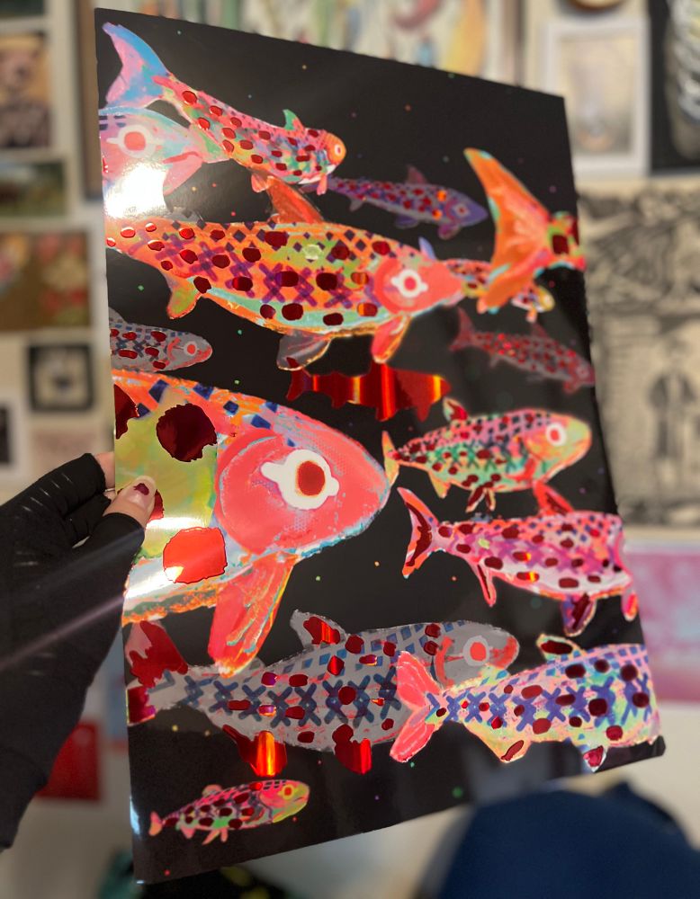 A tabloid sized print of a school of fish with red foil accents 