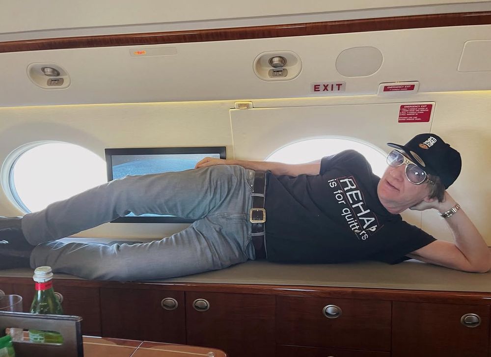 Bill Maher laying down in a full latter stage midlife crisis outfit 