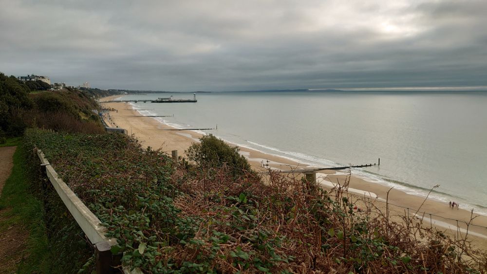 A colour photograph looking vaguely eastish across the beach and sea at Bournemouth from a vantage point overlooking the coast. It looks pretty cold and empty from a distance, but was in fact surprisingly busy despite the early hour (about 9am on a Sunday in December).