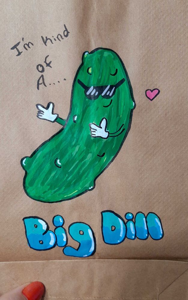 An acrylic marker illustration on a brown paper bag of a pickle in sunglasses saying "I'm kind of a big dill" 