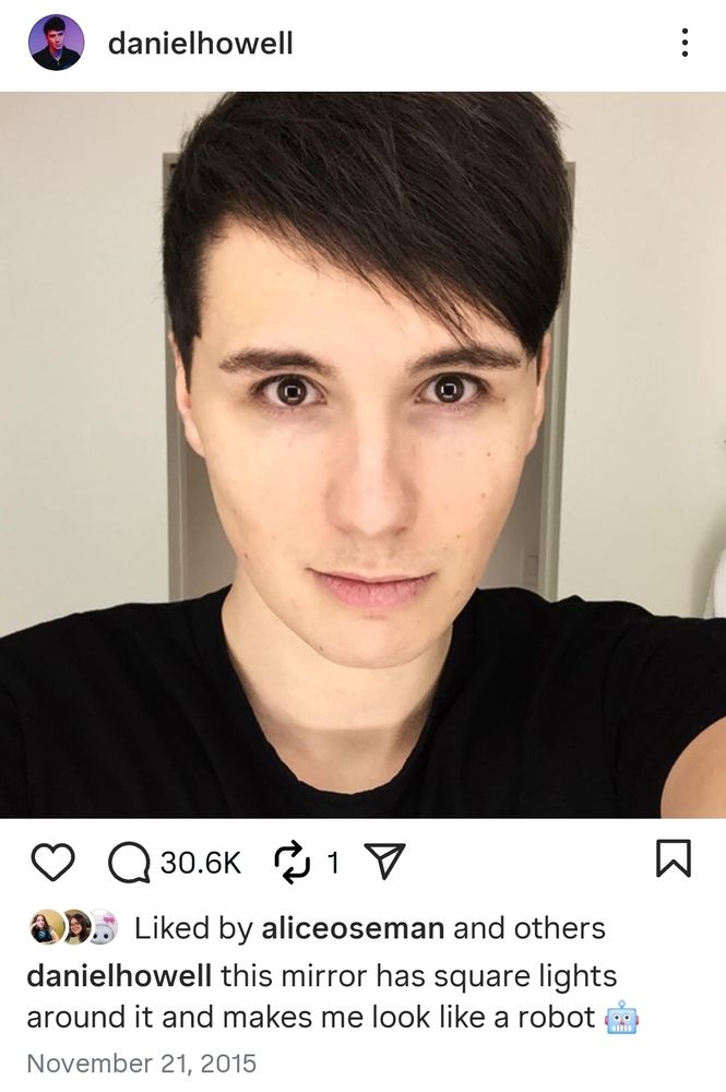 Instagram post from Dan Howell posted on 21 November 2015. The photo is a selfie of Dan in what appears to be a brightly lit bathroom at O'Hare International Airport in Chicago. The caption says "this mirror has square lights around it and makes me look like a robot" with a robot emoji at the end. The photo has been liked by Alice Oseman and others.