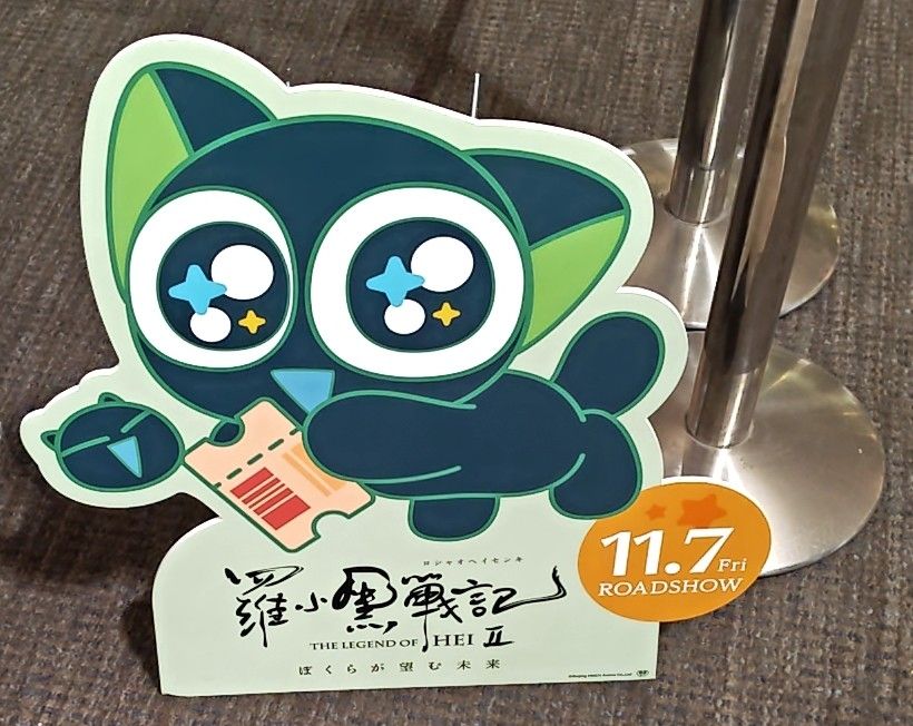 映画「ロシャオヘイセンキ　ぼくらが望む未来」の看板。猫の姿のシャオヘイとヘイシュウが写っています。