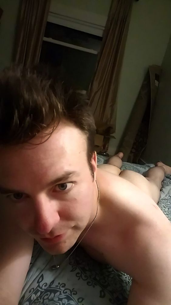 Me laying naked on bed looking into the camera