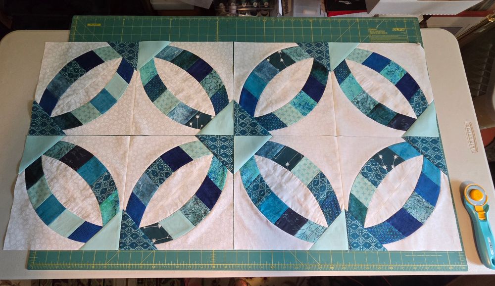 Blue/ teal/ white "Metro" wedding ring quilt section laid out.